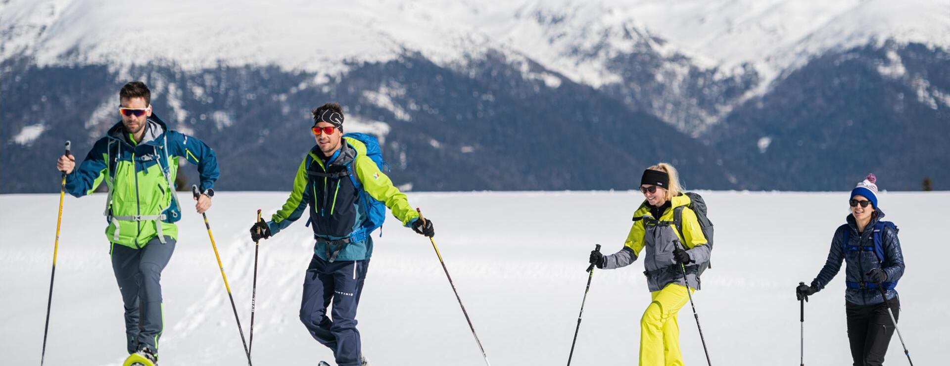 Four people are snowshoeing