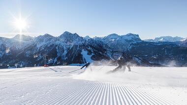 Zwei Skifahrer fahren eine Skipiste am Kronplatz bergab